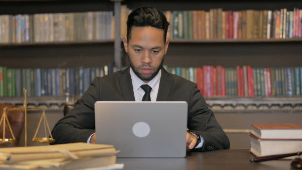 istock Hispanic Judge Working on Laptop in Courtroom 2194608611