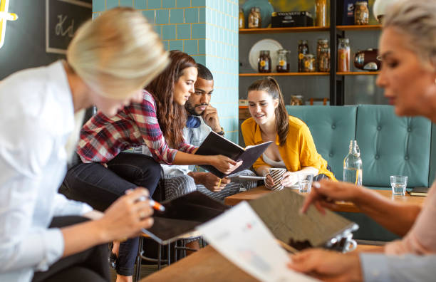 istock Diverse Group of Students Collaborating in Cozy Bistro 2194609125