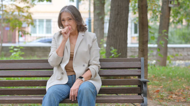 istock Coughing Old Senior Woman while Sitting in Park 2194609567