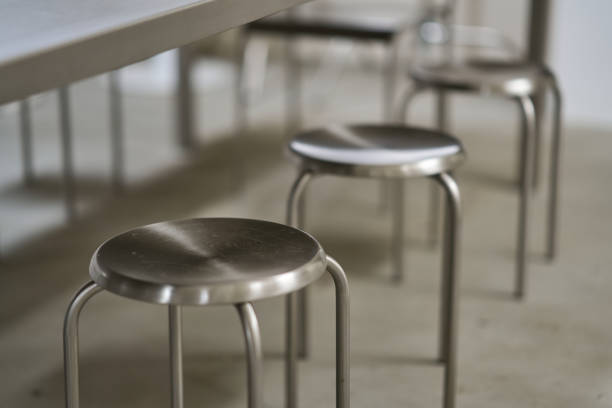 istock Row of metal stools under a table in a modern interior design setting 2194610457