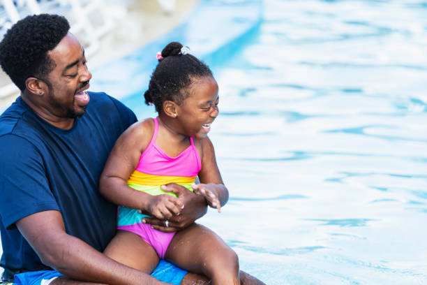 istock African-American father, daughter laughing in pool 2194612202