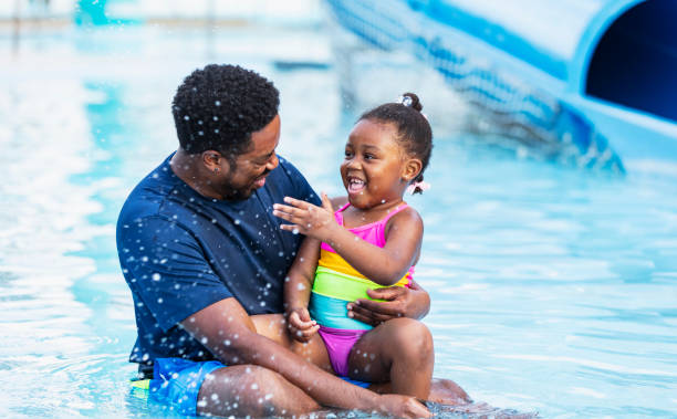 istock African-American father, daughter laughing in pool 2194612209