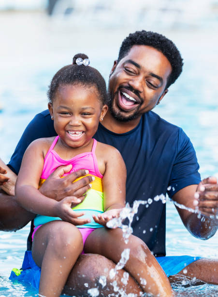istock African-American father, daughter laughing in pool 2194612211