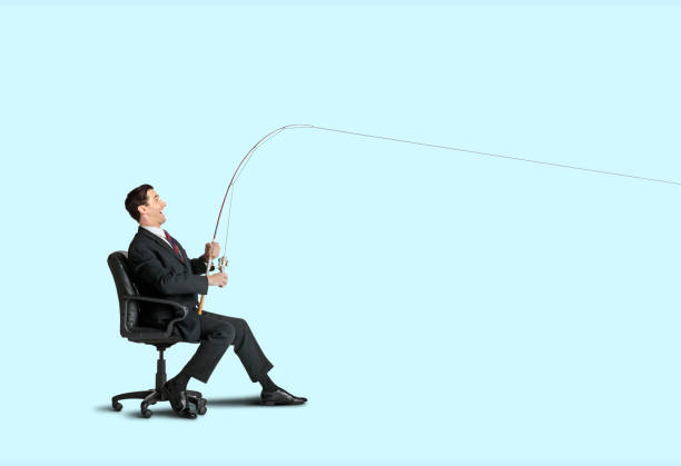 A man sitting in an office chair reels in a big one with his fishing pole.
