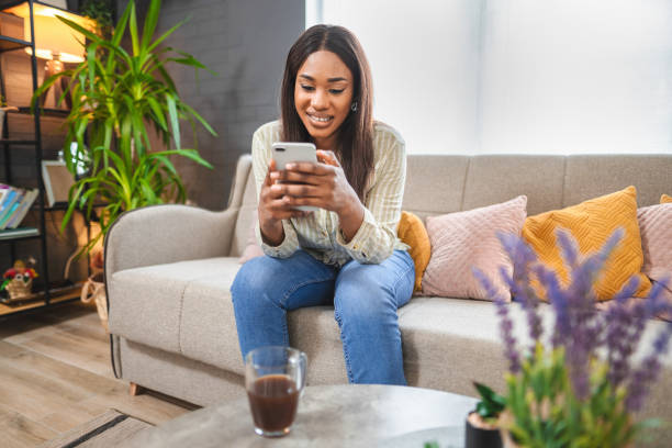 istock Young woman using smartphone and relaxing on comfortable sofa at home 2194616531