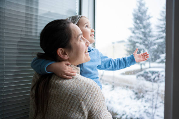 istock Happy Family Enjoying Snowfall From Window. Winter Mood 2194618189