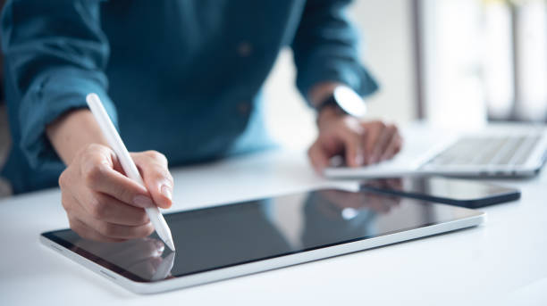 istock Close up, business woman using digital tablet and laptop computer at modern office 2194618786