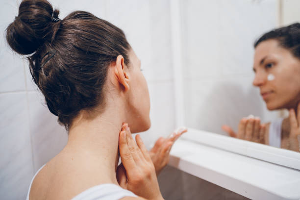 istock Beautiful woman using beauty cosmetics on neck 2194621793
