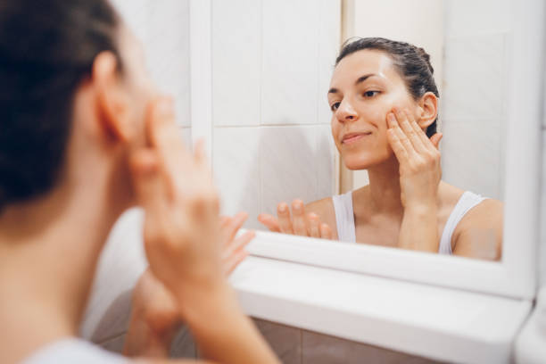 istock Beautiful woman using beauty cosmetics on face. 2194622182