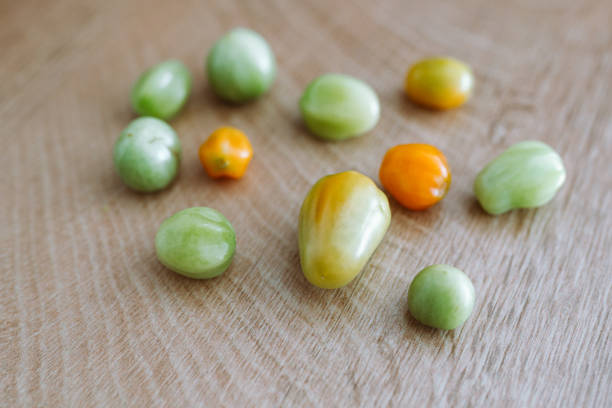 green unripe cherry tomatoes on a wooden board, unripe vegetables, storage, harvest