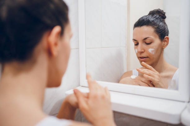 istock Beautiful woman using beauty cosmetics on face. 2194622427