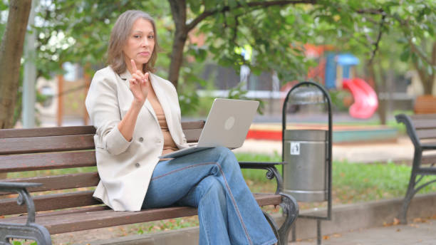 istock Old Woman in Denial while Using Laptop Outdoor 2194622451