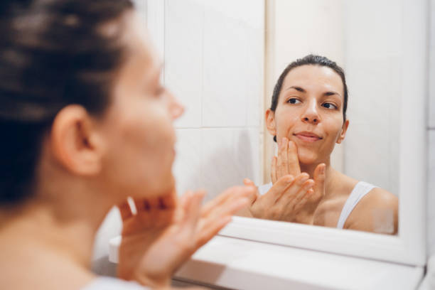 istock Beautiful woman using beauty cosmetics on face. 2194623229
