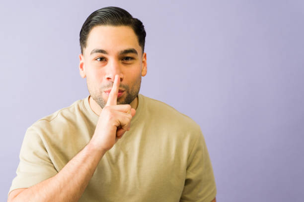 istock Young hispanic man making silence gesture on purple background 2194623521