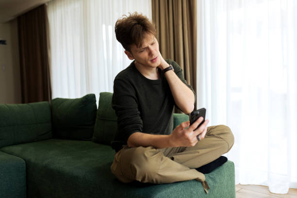 istock Young male using his phone at home 2194624015