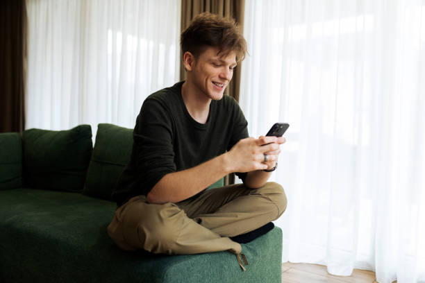 istock Young male using his phone at home 2194624028