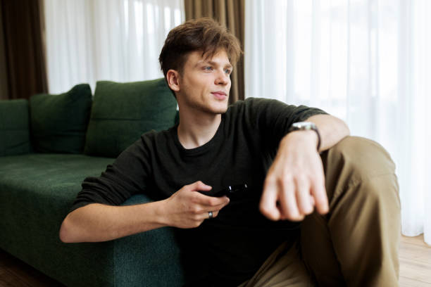 istock Young male using his phone at home 2194624112