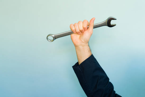 istock Mechanic raising wrench on gradient background 2194624684