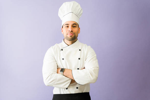 istock Confident latin chef crossing arms on purple background 2194625073