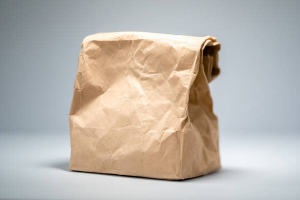 Brown paper bag with unknown contents on a neutral background.
