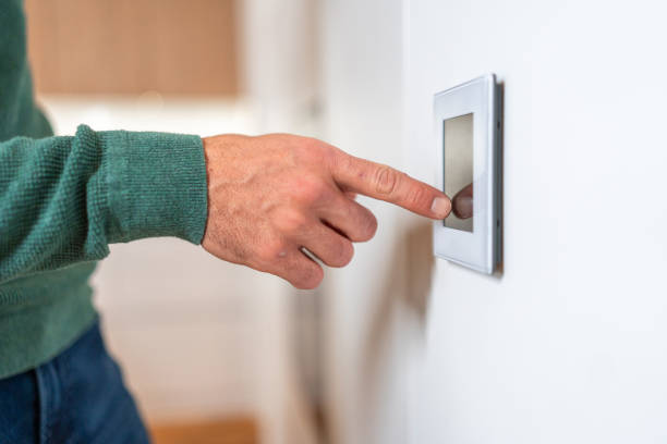 istock Male Hand Adjusting Smart Thermostat in Modern Home 2194629763