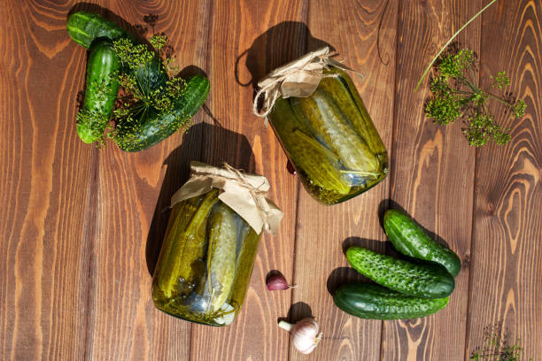 istock Pickled cucumbers in jars, fresh cucumbers on a wooden table . Home canning 2194632857