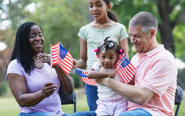 istock Multiracial family with American flags on US holiday 2194633882