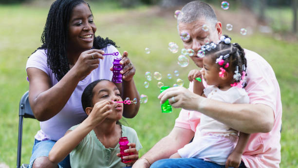 istock Multiracial family, two girls playing with bubble wands 2194633896