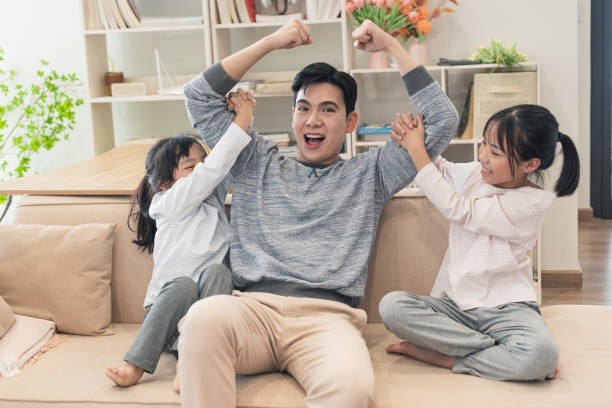 istock Asian father and two daughters at home 2194637348