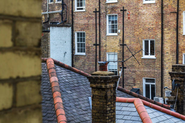 A classic urban scene featuring rooftops and brick buildings with chimneys, offering a glimpse into city architecture and atmosphere.