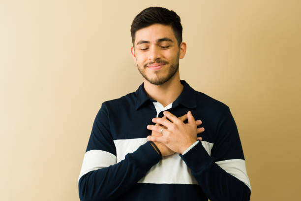 istock Young man expressing gratitude with hands on chest 2194639191