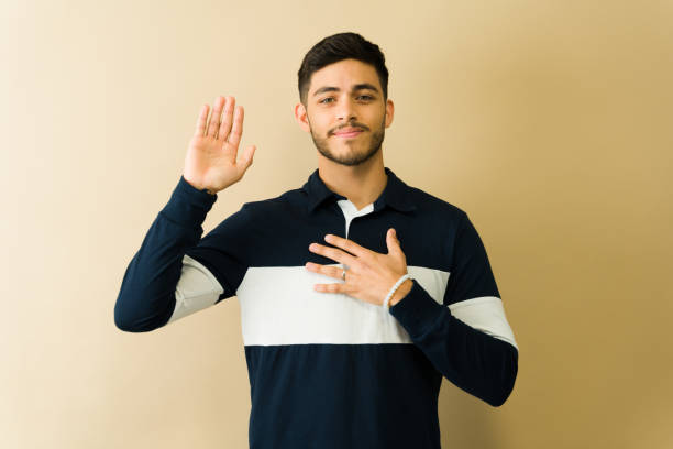 istock Serious Latin man taking an oath with hand on chest and raised hand 2194639267