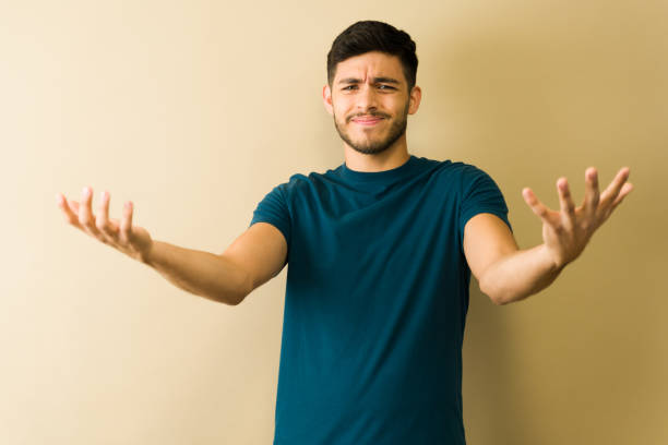 istock Young man showing helplessness with open arms and grimacing face 2194639356
