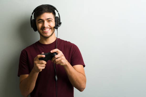 istock Young gamer wearing headset and holding controller, playing videogames and smiling 2194639594