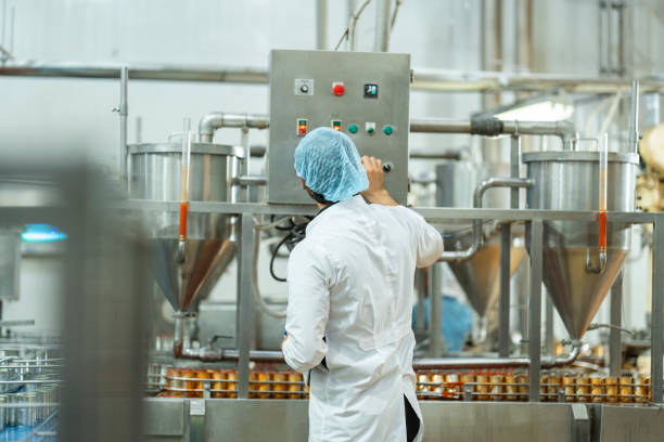 istock Inspector checking automated machinery in food production facility Focus on quality control safety and workflow efficiency. Worker overseeing food packaging machinery in a modern manufacturing plant. 2194643349