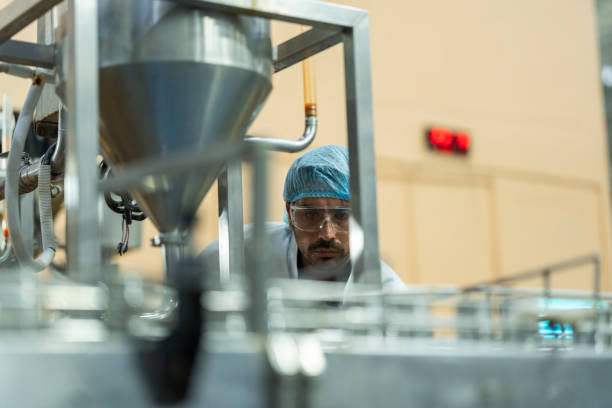 istock Inspector checking automated machinery in food production facility Focus on quality control safety and workflow efficiency. Worker overseeing food packaging machinery in a modern manufacturing plant. 2194643524