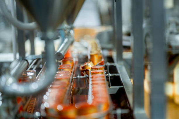 Canning process in a food production facility showing cans being filled and sealed Emphasis on automation cleanliness and manufacturing efficiency.