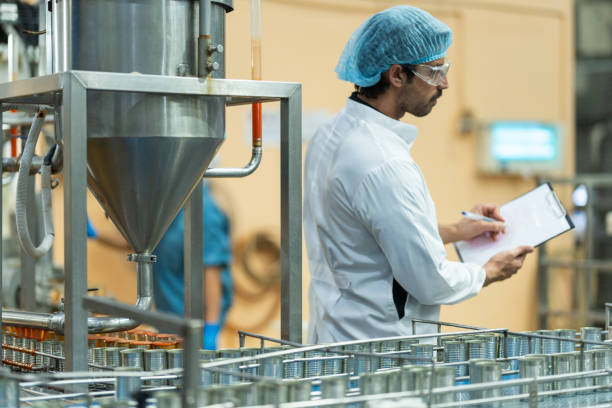 istock Inspector checking automated machinery in food production facility Focus on quality control safety and workflow efficiency. Worker overseeing food packaging machinery in a modern manufacturing plant. 2194643848
