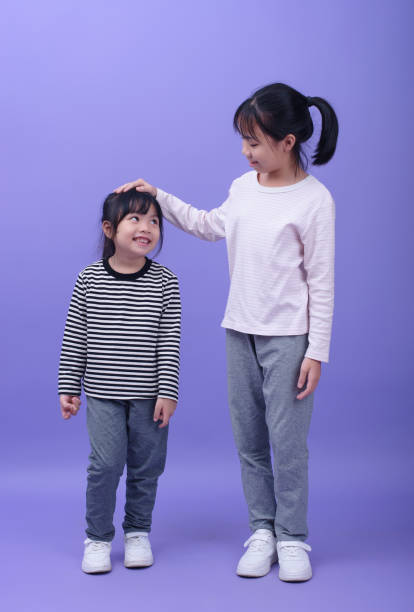 istock Two little girls on purple background 2194648854