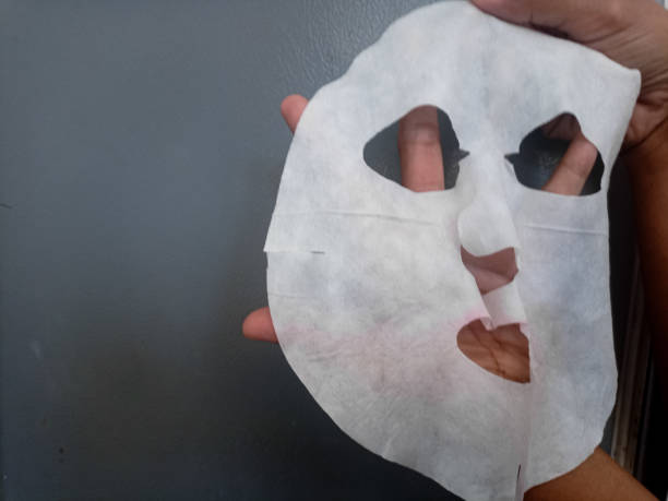 istock Female hands hold fabric sheet mask on gray background. 2194651224