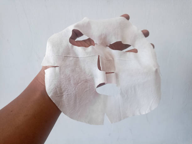 istock Female hands hold fabric sheet mask on gray background. 2194651328