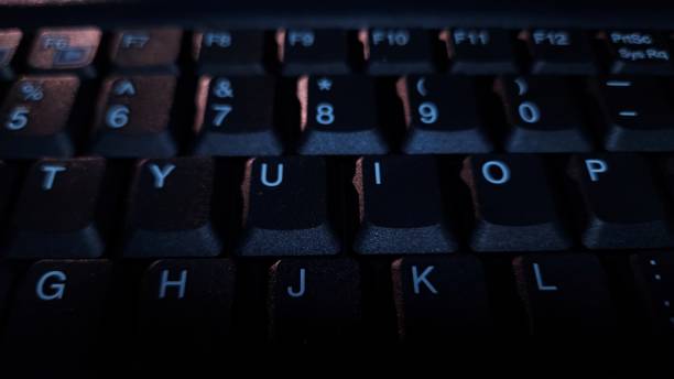 istock Close-up of computer keyboard in dark background. 2194654435