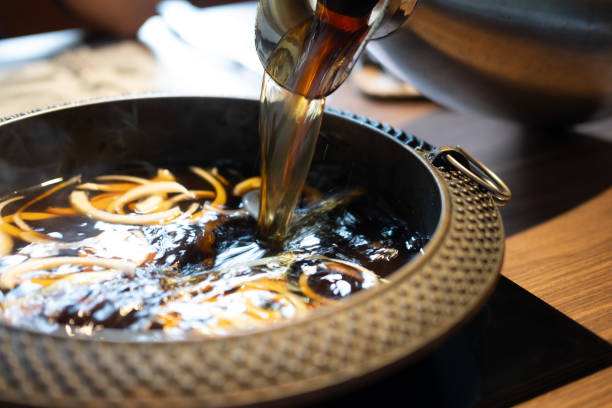istock Pour black soup in to hot pot with many onion. 2194655920
