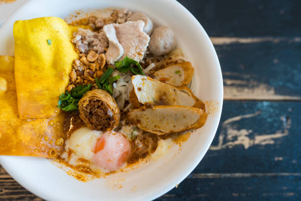 Delicious spicy tom yum noodle soup with pork with many topping