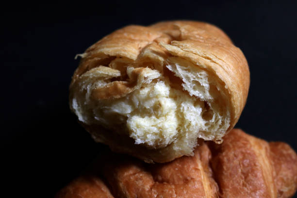 Photo of croissant bread, this crescent-shaped bread originates from Austria, but is popular in France. Croissants have a crunchy and layered texture, and are often enjoyed as breakfast or with coffee.