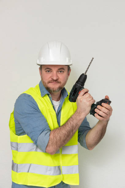 istock professional tool. builder with a drill at construction site. A drill is one of most versatile tools that is needed at every stage of construction. A tool in hands is an extension of personality 2194664288