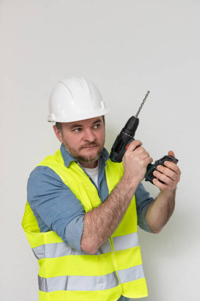 istock professional tool. builder with a drill at construction site. A drill is one of most versatile tools that is needed at every stage of construction. A tool in hands is an extension of personality 2194664340