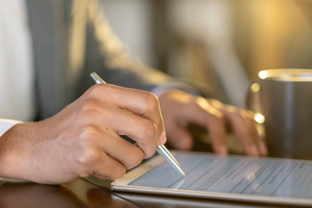 istock Businessman using stylus pen to fill out digital form on tablet 2194664633