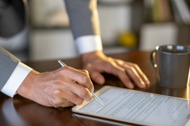 istock Businessman signing electronic document on tablet with stylus pen 2194664635