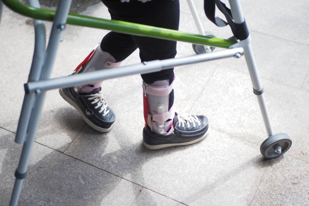 child with walking frame and knee orthosis outdoor .